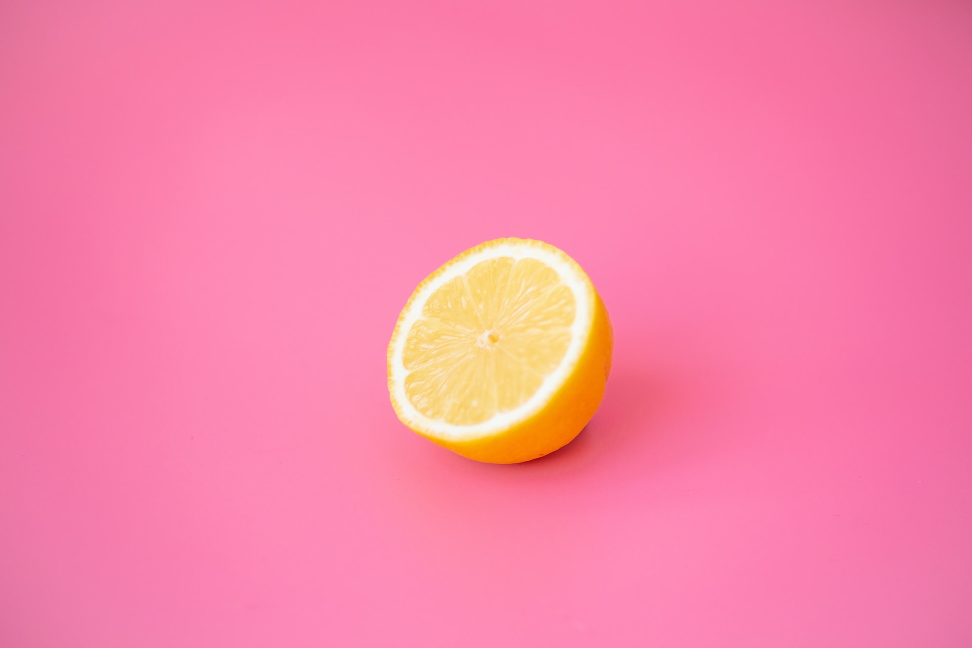 Medio limon sobre fondo rosa